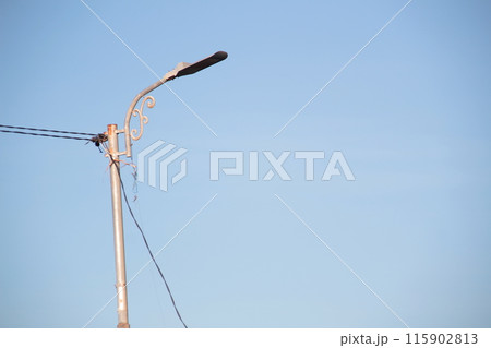 a solar-powered street light with a clear blue sky background. 115902813