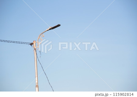 a solar-powered street light with a clear blue sky background. 115902814