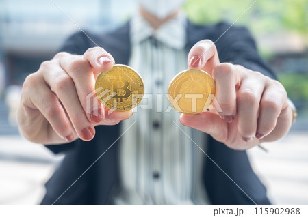 Close up of businesswoman holding Bitcoin and Dogecoin tokens. 115902988