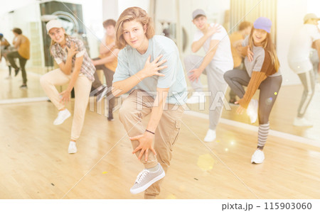 Teen b-boy dancing with group of friends in dance studio 115903060