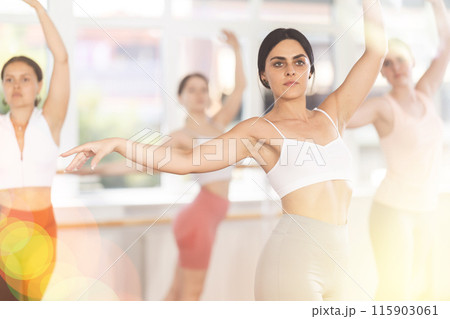 Young girl mastering ballet moves at group class 115903061
