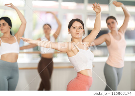 Close-up view of young girl practicing ballet positions standing in row 115903174