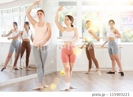 Two young girls demonstrating basic ballet positions 115903221