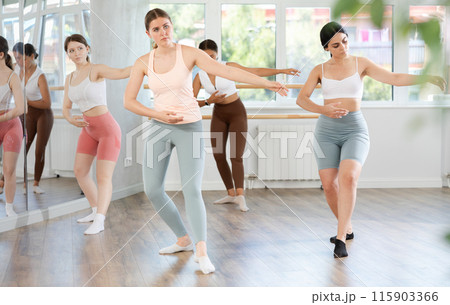 Teenage girl participating in beginner group ballet class 115903366