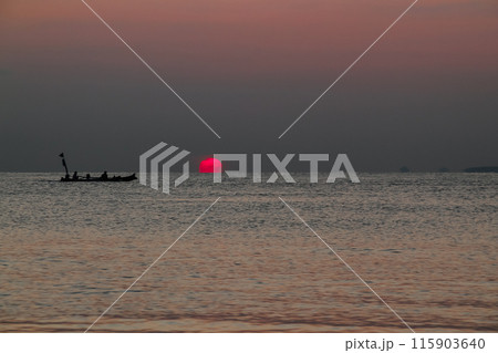 Beautiful sunrise on the sea and silhouette of a fishing boat 115903640
