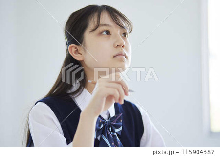 学校の教室で授業を受ける女子高生 115904387