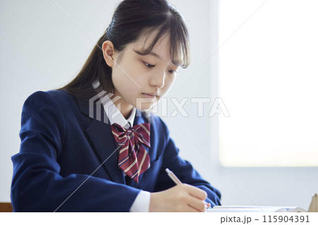教室の机で授業に集中する制服姿の女子高校生 教室の机で授業に集中する制服姿の女子高校生 115904391