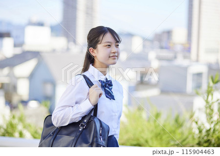 街を歩きながら笑顔を見せる制服姿の女子高校生 115904463