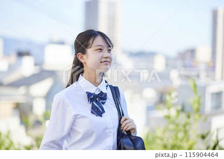 スクールバッグを肩に掛け通学する笑顔の女子高校生 スクールバッグを肩に掛け通学する笑顔の女子高校生 115904464