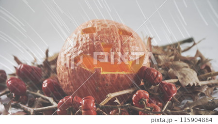 White light trails falling over halloween carved scary pumpkin against white background 115904884
