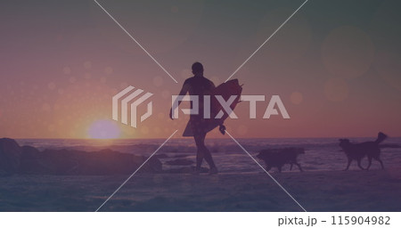 Image of glowing lights over man walking with surfboard by the sea 115904982