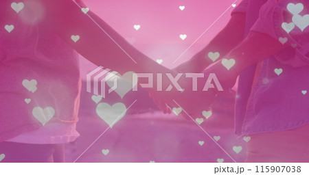Image of multiple heart icons falling over mid section of couple holding hands near the sea Image of multiple heart icons falling over mid section of couple holding hands near the sea 115907038