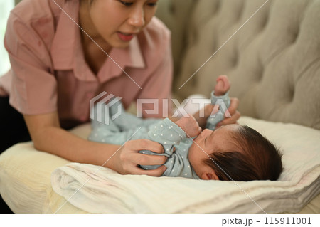 Beautiful young Asian mother with newborn baby enjoying tender family moment at home. Motherhood concept Beautiful young Asian mother with newborn baby enjoying tender family moment at home. Motherhood concept 115911001