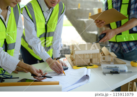 Engineer team having briefing about project reviewing blueprints at a building site Engineer team having briefing about project reviewing blueprints at a building site 115911079