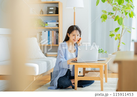 自宅でノートパソコンを操作する若い女性 115911453