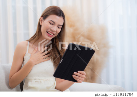Young asian woman sitting on sofa using digital tablet computer for video call. Young asian woman sitting on sofa using digital tablet computer for video call. 115911794
