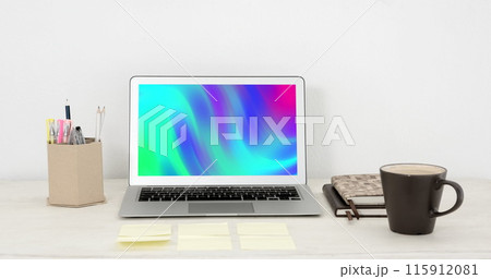 Image of laptop with colorful moving shapes on screen on desk 115912081