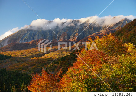 青空を背景にした鍵掛峠から観た雲が湧き立つ大山南壁と紅葉の風景　Ver2 115912249