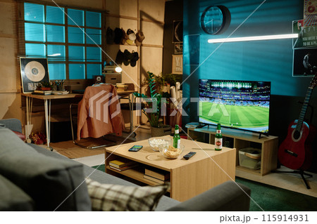 No people wide shot of modern living room interior with beer and snacks on table and soccer match on TV screen, copy space No people wide shot of modern living room interior with beer and snacks on table and soccer match on TV screen, copy space 115914931