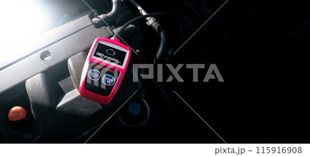 OBD2 or OBD scanner tool on car engine compartment for engine system analysis 115916908