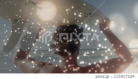 Image of lights over back view of caucasian surfer on beach 115917184