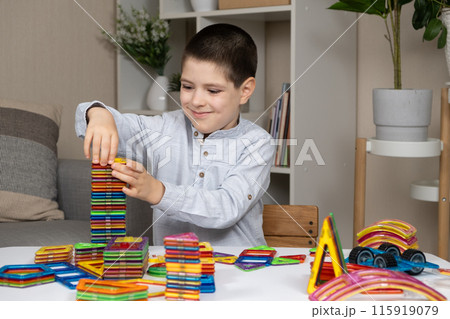 Boy building a tower from a magnetic construction set Boy building a tower from a magnetic construction set 115919079