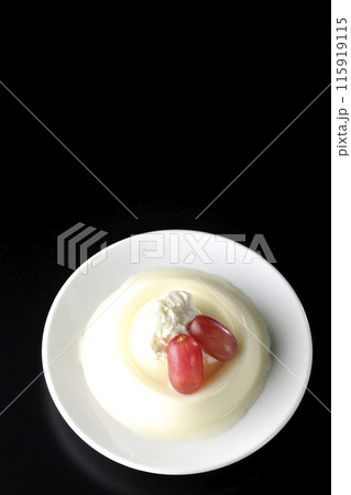 クリームと葡萄を乗せたパンナコッタを黒背景で俯瞰撮影 115919115