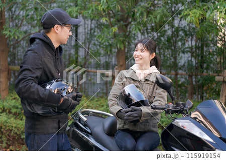 バイクに乗って話す男性と女性 バイクに乗って話す男性と女性 115919154