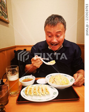 チャーハン、ギョーザ定食を食べる男性 115919763