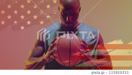 Image of american flag over focused african american male basketball player holding ball Image of american flag over focused african american male basketball player holding ball 115920353