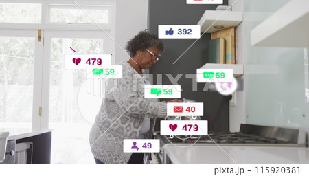 Image of social media text and icons over senior african american woman at home Image of social media text and icons over senior african american woman at home 115920381