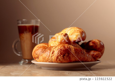 Freshly baked croissants and coffee with cream. 115922322