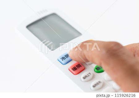 エアコンのリモコンを持つ男性の手元 エアコンのリモコンを持つ男性の手元 115926216