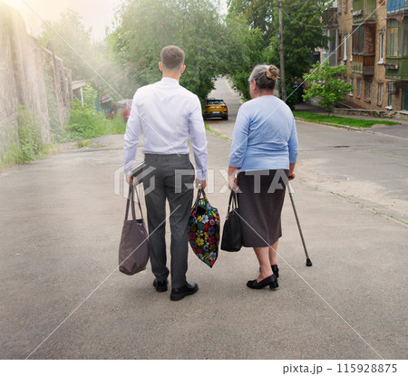 Man helping old woman to carry bags Man helping old woman to carry bags 115928875
