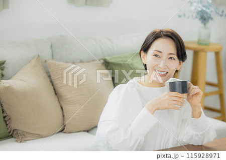 リビングでコーヒーを飲むミドル女性 115928971