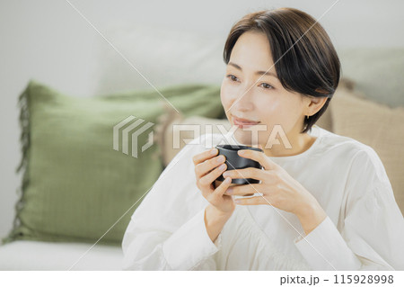 リビングでコーヒーを飲むミドル女性 115928998