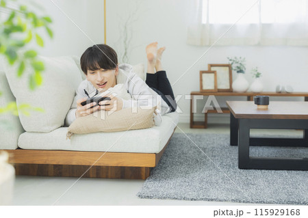 リビングでくつろぐ若い男性　 115929168