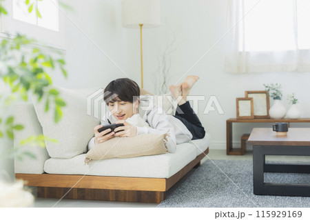 リビングでくつろぐ若い男性　 115929169