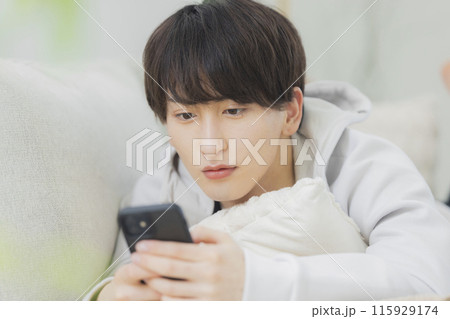 リビングでくつろぐ若い男性 リビングでくつろぐ若い男性 115929174