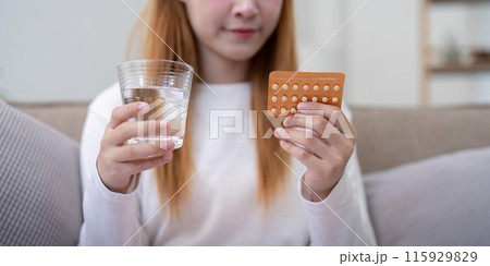 Woman Holding Birth Control Pills and a Glass of Water, Promoting Contraceptive Health and Family Planning Woman Holding Birth Control Pills and a Glass of Water, Promoting Contraceptive Health and Family Planning 115929829