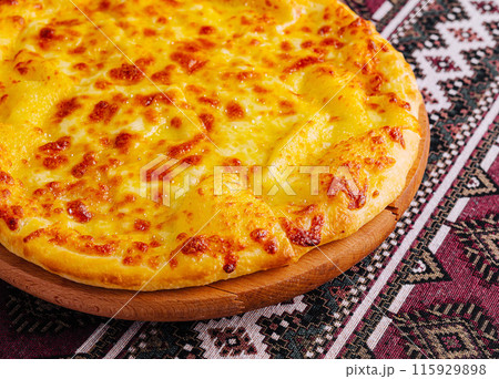 Delicious cheese pizza on traditional tablecloth 115929898
