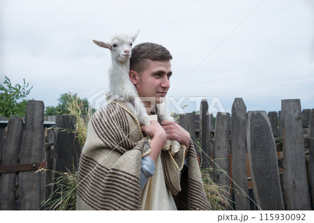 Shepherd with a sheep in his arms 115930092