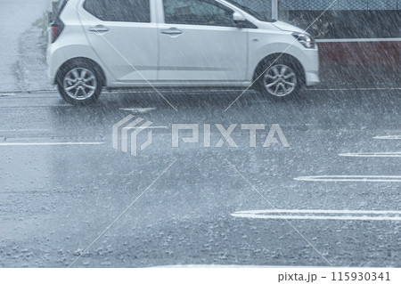 雨の日の道路を白い車が走っている 雨の日の道路を白い車が走っている 115930341