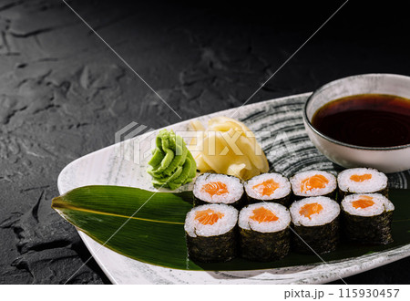Exquisite sushi platter with soy sauce on dark background Exquisite sushi platter with soy sauce on dark background 115930457