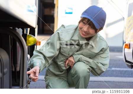 車両を点検するトラックドライバーの若い女性 115931106