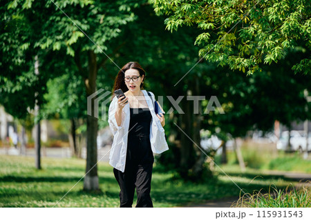 スマホを持って街を走る若い女性 スマホを持って街を走る若い女性 115931543
