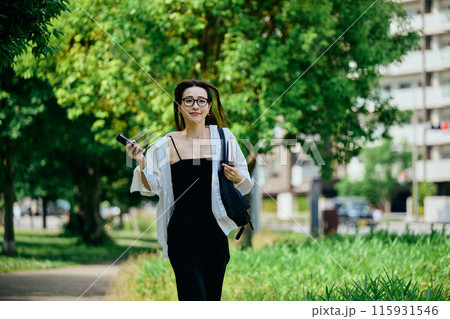 スマホを持って街を走る若い女性 スマホを持って街を走る若い女性 115931546