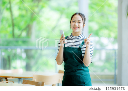 スマホを持つカフェの店員 スマホを持つカフェの店員 115931678
