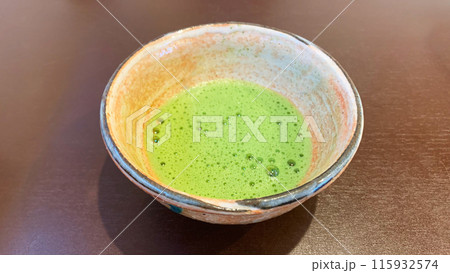 テーブルの上に置かれた本格的な抹茶の一杯 115932574