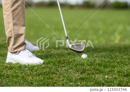 Close up of a guys feet in sneakers on the grass playing gold 115933746